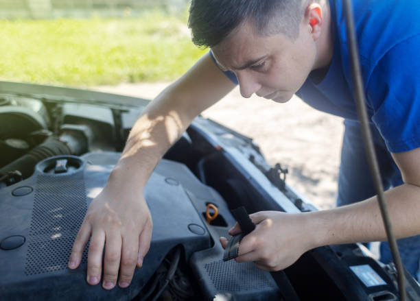 Shock due to irreparable damage. Timing belt break. Man near hood of car is looking for a malfunction due to which the engine does not work. Driver is holding a broken front belt in his hands. rotura de la correa de distribución. el hombre cerca del capó del automóvil está buscando un mal funcionamiento debido a que el motor no funciona. el conductor sostiene un cinturón delantero roto en sus manos. choque debido a daños irreparables.