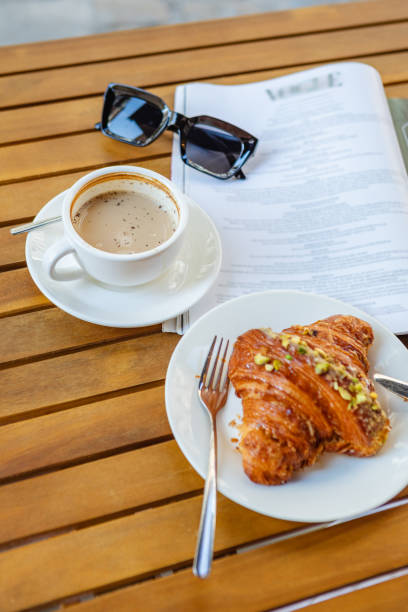 istock Morning coffee and croissant with reading material 1496059201