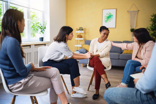 During group therapy people consoling woman of Black ethnicity