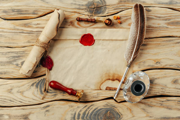 istock Old paper on brown wood background with feather 1496061353