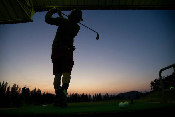 golf player silhouette Man swinging a golf club golf player silhouette Man swinging a golf club night golf stock pictures, royalty-free photos & images