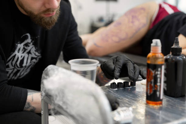 istock Tattoo artist prepares tools and ink before working in a tattoo parlor. 1496063753