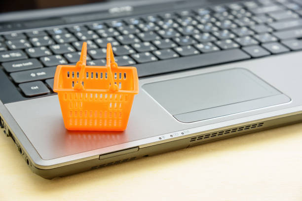 Online shopping and goods delivery service, ecommerce concept : Plastic household basket and a laptop computer, depicting a consumer or buyer conveniently buys items from their home using the internet servicio de compras en línea y entrega de bienes, concepto de comercio electrónico: cesta doméstica de plástico y una computadora portátil, que representa a un consumidor o comprador que compra artículos convenientemente desde su hogar a través de i