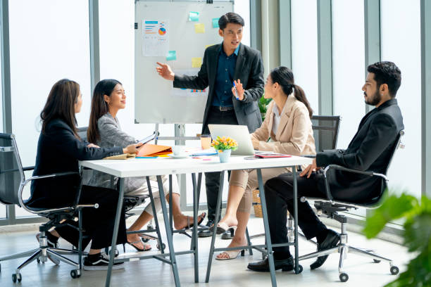 istock Asian business man present the project on whiteboard to co-worker and manager with day light in office and they look happy to work together. 1496067758