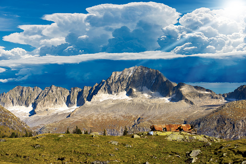 Mountain peaks against beautiful storm clouds (cumulonimbus). Adamello and Brenta National Park, peak of the Care Alto (3462 m). Italian Alps, Trentino Alto Adige, Italy, Europe.