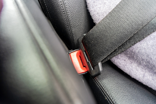 Women's hand fastening the seat belt of a car