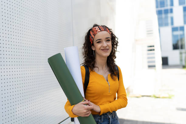 istock Smiling woman architect student holding paper drawing blueprints 1496081204