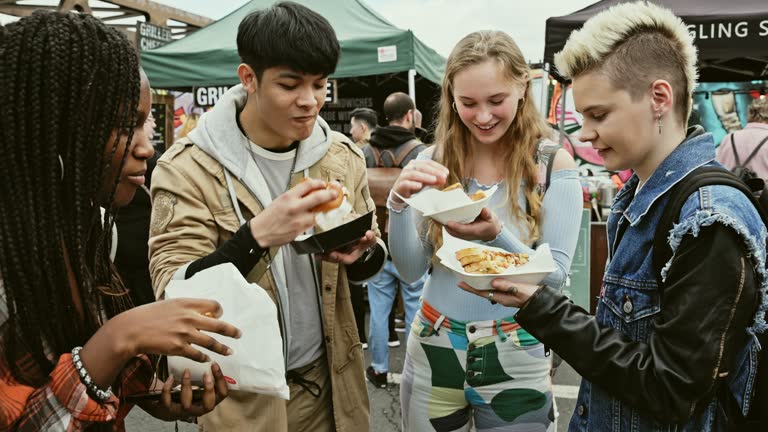 Four hungry Londoners enjoying street food for lunch