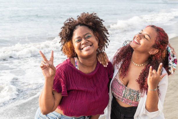 istock friends smiling and looking at camera while standing on tropical beach 1496085325