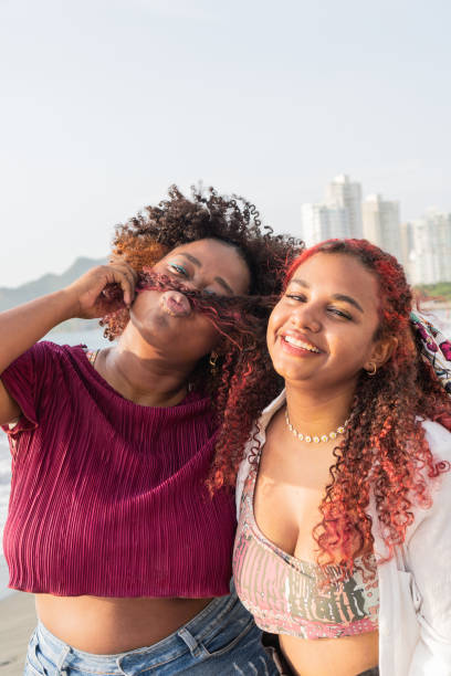 istock happy young friends having fun while standing on the beach. 1496085384