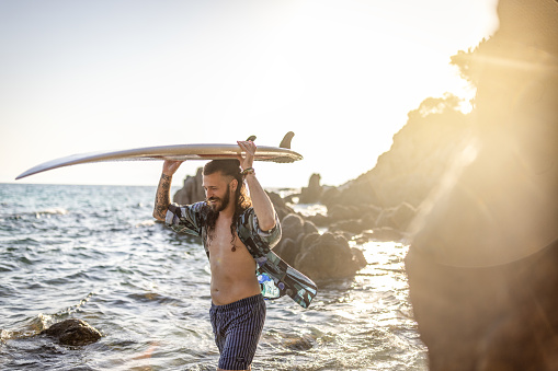 Surfer man on the beach with surfboard