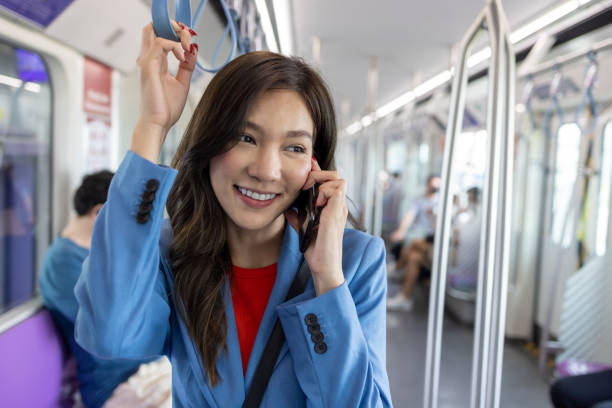 istock Asian woman using mobile phone device taking the train to work 1496087505