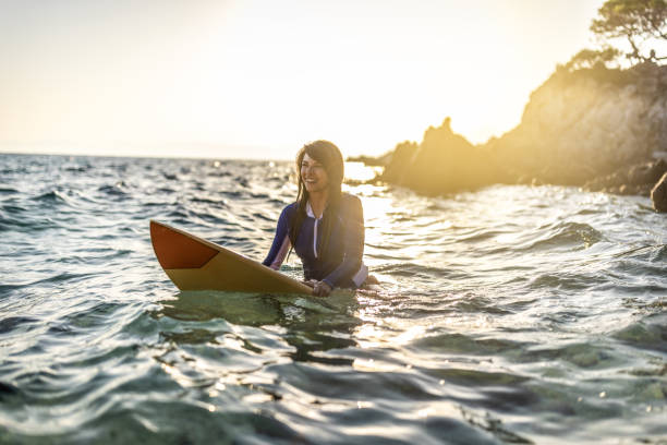 istock Woman in wetsuit with a surfboard 1496087853