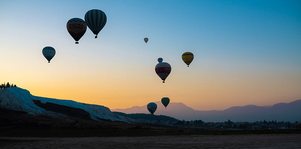 A Serene Sunrise at Pamukkale National Park with Hot Air Balloons in Sight