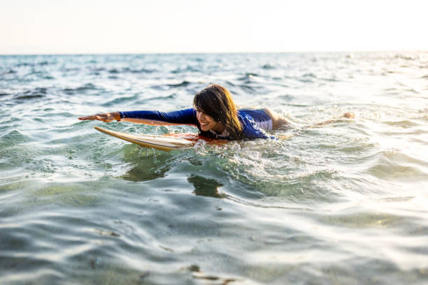 istock Woman in wetsuit with a surfboard 1496089380