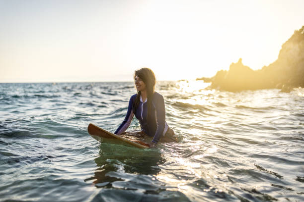 istock Woman in wetsuit with a surfboard 1496089505