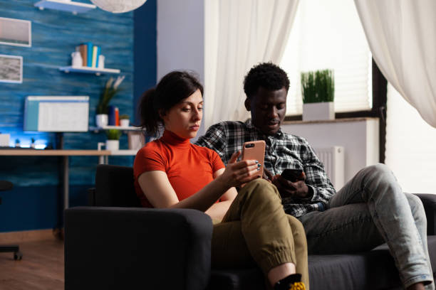 istock Interracial couple sitting on couch relaxing at home 1496092516
