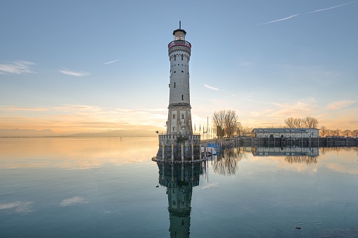 A picturesque lighthouse tower stands against the backdrop of a sunset