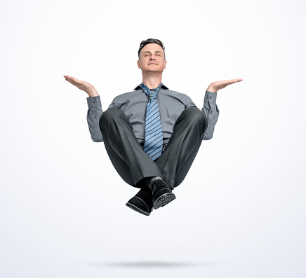 Happy man in office clothes levitates in the air, in a relaxed pose, isolated on a light blue background.