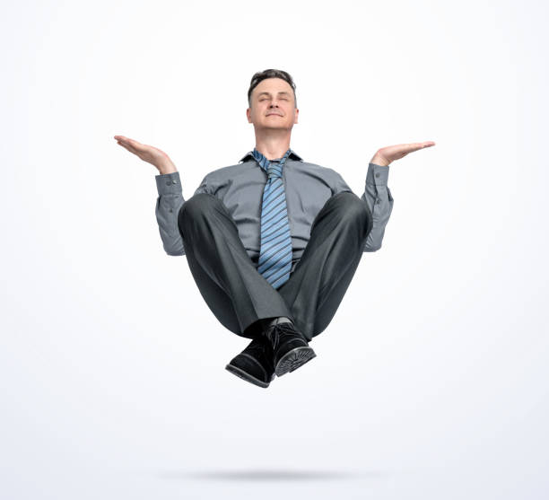 happy man in office clothes levitates in the air, in a relaxed pose, isolated on a light blue background. - men businessman jumping levitation imagens e fotografias de stock