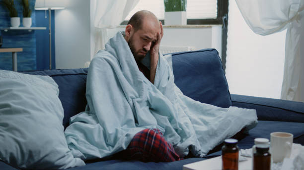 istock Sick man rubbing temples against headache and cold 1496095862