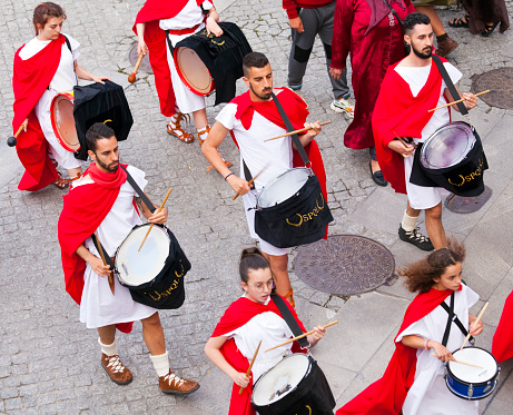 Lugo, Spain- June 11, 2022: Group of drummers in Roman soldiers parade, traditional festival recreation , high angle view of Arde Lucus traditional festival parade, Roman Historical Reenactment. Drummers marching band, street artists. Lugo city, Galicia, Spain.