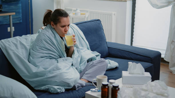 istock Woman with flu drinking effervescent medication with water 1496098033
