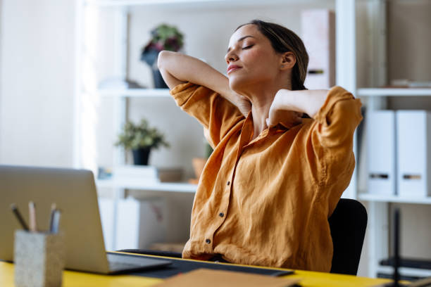 istock A Tired Beautiful Blonde Businesswoman Stretching While Working In The Office On Her Computer 1496098052