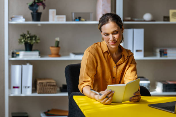 istock A Happy Beautiful Blonde Businesswoman Reading Her Notes While Working In The Office 1496098130
