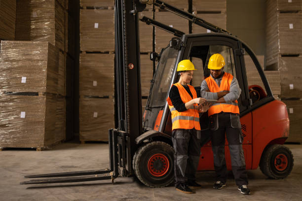 istock Two factory employees working in a warehouse 1496099736