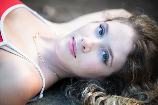 beautiful blond woman looking at camera outdoor, toned image