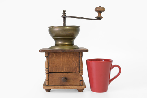 old wooden coffee mill and red coffee mug. white background, isolated. mockup