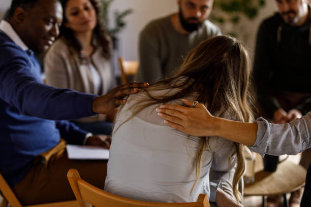 istock Mature woman sitting with head in hand while sharing her emotions during a group therapy session 1496102016