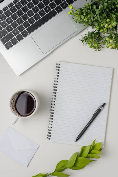 istock Workspace with laptop, office supplies, and coffee cup on white background. Top view. 1496103734