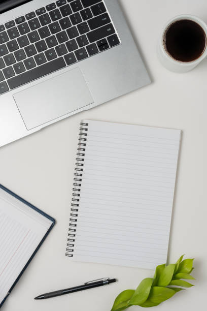 istock Workspace with laptop, office supplies, and coffee cup on white background. Top view. 1496103736
