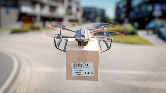 A delivery drone is flying between residential buildings - the concept of delivering packages using an unmanned drone