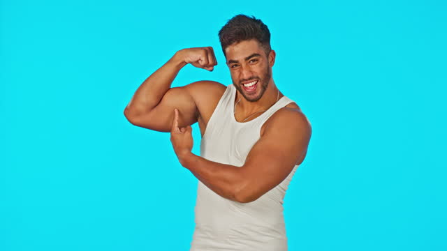 Fitness, blue screen and man flexing muscle on mockup space for information or tips on body growth in studio. Mock up, exercise and healthy motivation by Indian personal trainer or sports instructor