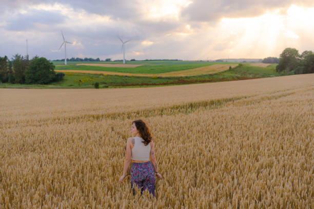 istock Woman walking among wheat field crop 1496108558