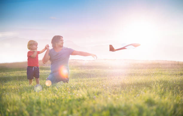 istock Father and Son Launching a Toy Airplane 1496109265