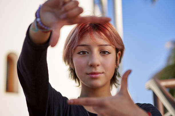 head shot portrait latin woman teenager gesturing framing with hands stock photo