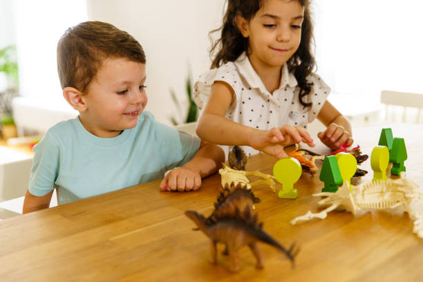 istock Children having fun playing with dinosaur toy on the kitchen island 1496110065