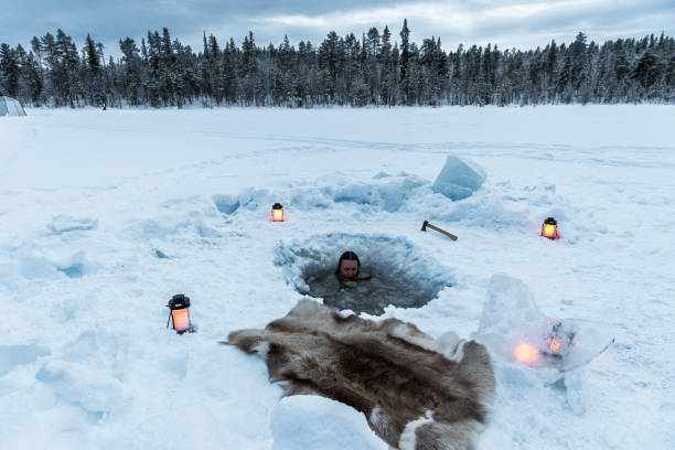 Person relaxing while ice bathing View of a beautiful girl enjoying the ice bath in the arctic landscape, Sweden swedish sauna stock pictures, royalty-free photos & images