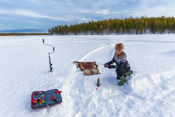 얼어붙은 호수에서 얼음을 뚫고 겨울 낚시 - ice fishing 뉴스 사진 이미지