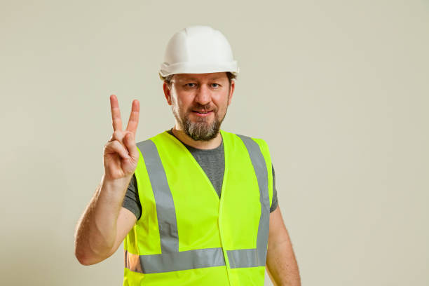 istock worker in a vest and white helmet 1496111188