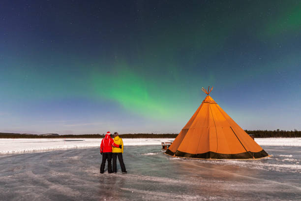 istock Couple looking at northern lights displaying in the sky 1496111297