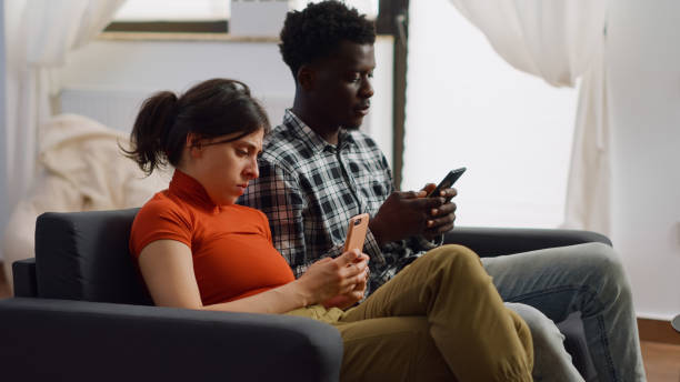 istock Modern interracial people holding smartphones on couch 1496111382