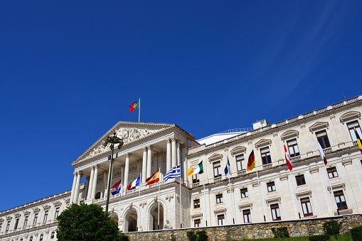 Lisbon, Portugal: Portuguese Parliament - São Bento Palace with EU countries flags - built at the end of the 16th century as a Benedictine monastery, designed by Baltazar Álvares, it became the seat of the parliament in 1834, now called Assembly of the Republic ('Assembleia da República'). The Assembleia is unicameral parliament, with 230 members, elected by multi-member constituencies for 4-year terms.