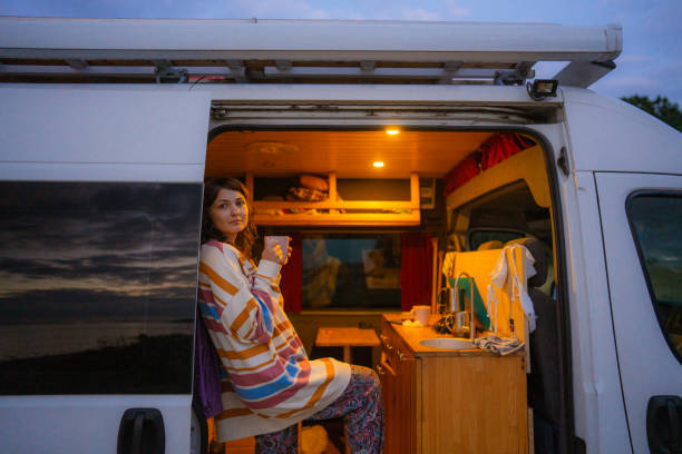 istock Woman drinking tea in camper van at the beach 1496112898