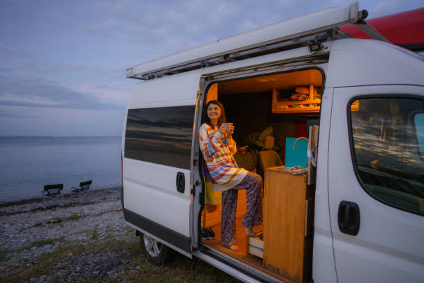 istock Woman drinking tea in camper van at the beach 1496113123