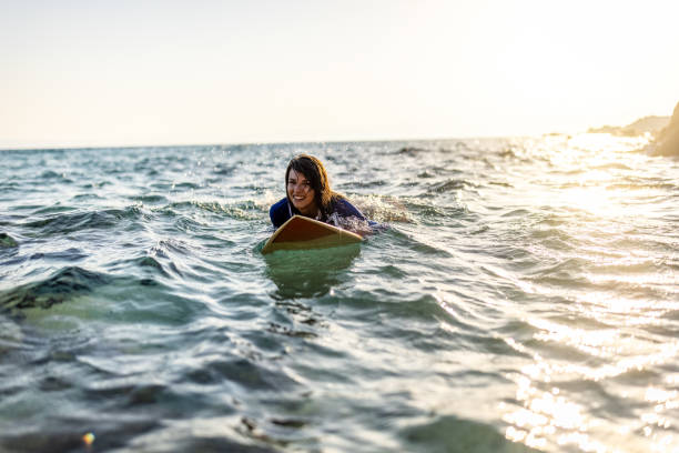 istock Woman in wetsuit with a surfboard 1496113414